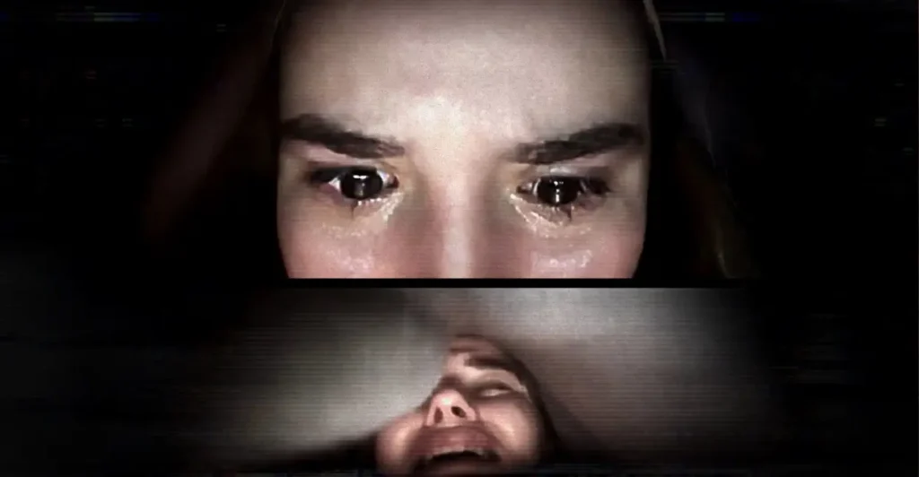 Cena do filme Host: Cuidado com Quem Chama (2020), com a personagem Haley (interpretada por Haley Bishop) em desespero durante uma chamada de vídeo, com olhos lacrimejantes e expressão de pânico, em um dos momentos mais assustadores do terror digital gravado inteiramente em videoconferência.