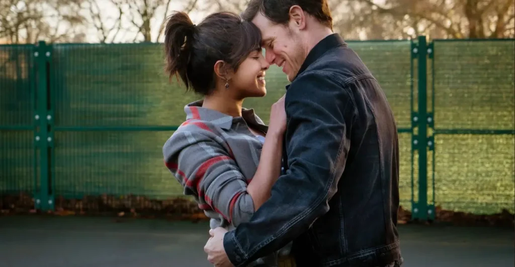 Cena do filme O Amor Mandou Mensagem (2023), com casal sorridente abraçado em um encontro ao ar livre — comédia romântica sobre reencontros e segundas chances no amor.
