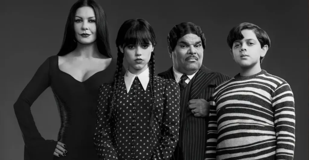 Elenco da série Wandinha com Mortícia, Wandinha, Gomez e Feioso Addams em retrato oficial em preto e branco, destacando o visual gótico clássico da Família Addams.