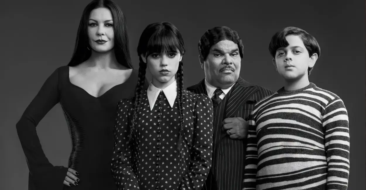 Elenco da série Wandinha com Mortícia, Wandinha, Gomez e Feioso Addams em retrato oficial em preto e branco, destacando o visual gótico clássico da Família Addams.